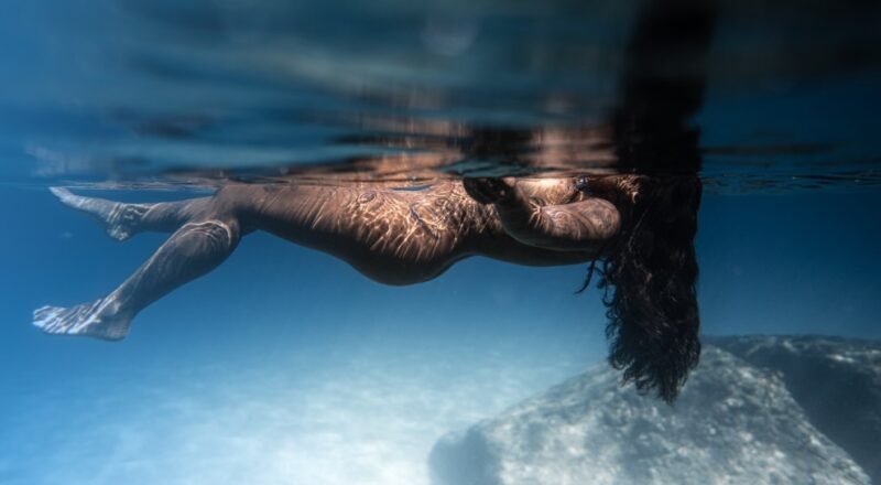 Naked woman swimming in ocean